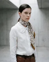 Pañuelo cuadrado de seda natural con estampado artístico de manchas abstractas en tonos tierra y gris, con borde ancho en color marrón.