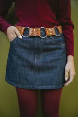 Cinturón marrón con textura símil piel de cocodrilo, argollas plateadas y remaches.