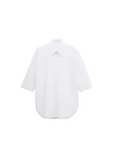 Camisa de algodón de diseño recto, cuello camisero, manga tres cuartos y cierre delantero de botones ocultos con tapeta.