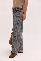 Pantalón jean de algodón con corte barrel y tiro bajo, de color azul, con bolsillos delanteros y traseros.