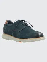 Zapato de estilo casual tipo derby en color azul marino, confeccionado en cuero con detalles de perforaciones decorativas tipo brogue. Cuenta con cordones al tono, detalle en cuero color suela en el talón y suela de goma flexible color gris claro con tecnología de amortiguación.