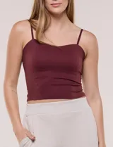 Top crop ajustado negro de estilo corsé, con tirantes finos regulables y escote corazón. Cuenta con costuras verticales decorativas en el frente.