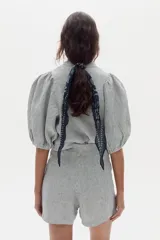 Short de lino con diseño a rayas en tonos celestes y blancos, con pinzas frontales y tiro alto.