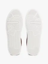 Zapatillas de estilo tenis Tommy Hilfiger confeccionadas en piel color marrón, con diseño de corte bajo, cordones al tono y suela de goma blanca. Presenta un panel de gamuza a contraste en el talón y el logo de la marca grabado en el lateral.