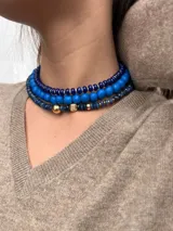 Collar corto de cuentas facetadas color azul con detalles de cuentas doradas.