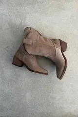 Bota estilo texana de gamuza color beige, con bordados decorativos en la caña media y taco cuadrado de madera.