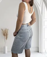 Musculosa ajustada de tejido acanalado (morley), con escote redondo y bordes ondulados en el ruedo. Disponible en colores beige, blanco y negro.