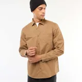 Camisa de manga larga color marrón claro, con cuello clásico, un bolsillo de parche en el pecho izquierdo y botones frontales.