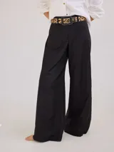 Pantalón negro de pierna ancha con tiro medio alto y pretina elastizada en la espalda. Presenta bolsillos plaque en delantera y espalda.