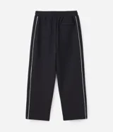 Pantalón deportivo de corte recto y estilo holgado, color negro con una línea vertical blanca en los laterales. Cuenta con cintura elástica con cordón de ajuste y bolsillos laterales.