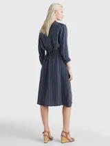 Vestido camisero midi azul marino con rayas verticales blancas, cuello camisero, cierre frontal con botones, mangas largas con puños abotonados y cinturón de lazo a juego.