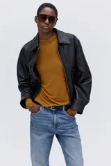Top de punto mostaza con cuello alto y mangas largas, con detalles de terminación ondulada en puños y bajo.