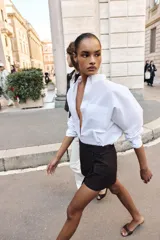 Falda pantalón cruzada de color marrón oscuro, con diseño tipo cargo que incluye bolsillos laterales con solapa y botones decorativos en la cintura.