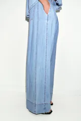 Jeans de tiro medio con corte wide leg y pinzas delanteras. Presenta bolsillos frontales, bolsillos de plastrón en la parte trasera, cierre frontal con cremallera, botón interior y ganchos metálicos.