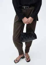 Pantalón de vestir de corte wide leg en color marrón, con diseño de tiro medio, detalle de pinzas frontales, bolsillos laterales y cierre frontal con cremallera, gancho y doble botón.