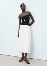 Vestido midi combinado con cuerpo palabra de honor negro de tejido elástico y falda blanca abullonada de estilo globo en algodón.