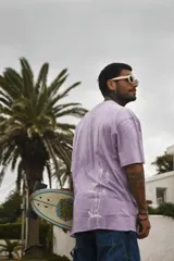 Remera color beige de algodón premium, manga corta y cuello redondo. Presenta un estampado circular en el centro del pecho con un diseño abstracto en tonos grises.