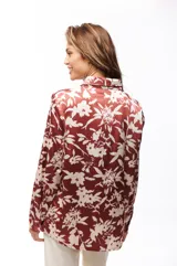 Camisa marrón con estampado floral blanco, de corte recto y mangas largas.