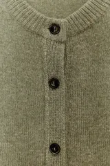 Chaqueta de tejido de punto color verde musgo, de corte cropped, con cuello redondo y cierre frontal de botones oscuros.