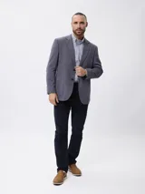Blazer de piqué en color azul, con solapa clásica, cierre frontal de dos botones y bolsillos laterales de parche.