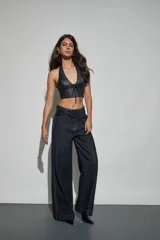 Jean de denim azul oscuro con diseño de tiro alto, piernas anchas de corte recto y costuras pespunteadas en contraste. Incluye un cinturón integrado con hebilla forrada y pasadores anchos.