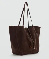 Bolso tipo shopper de piel de serraje, con dos asas de hombro, cierre de botón magnético y cierre de lazo. Cuenta con un bolsillo interior con cremallera y forro de algodón.