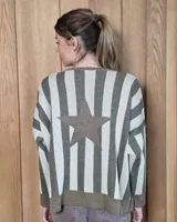 Buzo de punto con diseño de rayas verticales en tonos tostado y beige, con una estrella grande en la espalda y terminaciones en color verde oliva. Presenta un corte holgado y mangas anchas.
