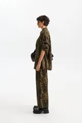 Pantalón de corte recto con estampado animal print en tonos verde y negro, confeccionado en algodón.