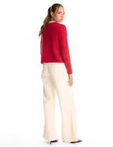 Chaqueta de tejido mohair color rojo, con cuello a la base decorado con bordado de perlas y canutillos. Presenta cierre frontal con broche interno, bolsillos simulados y detalles de apliques brillantes en los bordes.