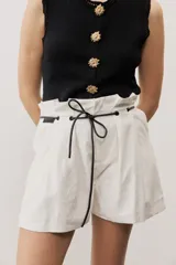 Short blanco de tiro alto, confeccionado en lino, con bolsillos laterales y cordón ajustable en la cintura.