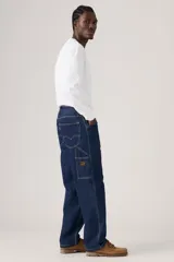 Jeans de denim azul oscuro con corte holgado y recto, estilo carpintero, con trabillas para cinturón y bolsillos funcionales.