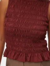 Blusa sin mangas color bordó con cuello redondo, calce regular y detalle de smock en todo el cuerpo, con terminación con volados.