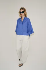 Camisa de mezcla de algodón de corte oversize y diseño asimétrico en tono azul, con cuello solapa, mangas tipo kimono por debajo del codo y cierre lateral con botones.