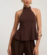 Blusa marrón oscuro con cuello halter y corte peplum, ajustada al cuerpo con pences frontales.