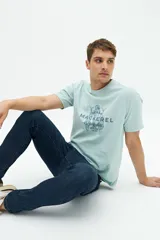 Remera celeste de manga corta con estampado de peces y texto en el frente.