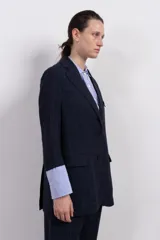 Blazer azul marino con diseño cuadrillé, corte clásico, solapas de muesca, cierre frontal con dos botones, bolsillos de parche y confección en tejido de lino y viscosa.