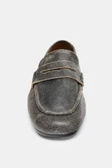 Mocasín plano de piel, color negro con efecto desgastado o envejecido, de punta redonda y con antifaz en el empeine.