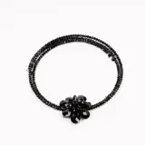 Collar de tres hilos de cuentas negras con dije de flor de cristal tornasol.