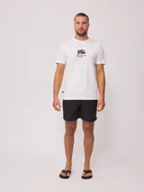 Remera blanca de algodón con estampado gráfico en la espalda. El diseño presenta el logo de Rusty en negro sobre un fondo rectangular lila, con tipografía angular.