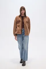 Campera tipo shacket de corderito color crema, con detalles en pana marrón en cuello, solapa de botones y bolsillos frontales. Diseño holgado de manga larga con cierre frontal de botones.