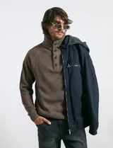 Campera técnica de tejido elástico en color azul marino, con capucha ajustable, cierre frontal y bolsillos laterales con cierre. Cuenta con forro interior de micro polar y ajuste en el ruedo.