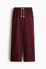 Pantalón jogging amplio de punto suave de algodón, color bordó, con cintura elástica, cordón ajustable blanco y bolsillos al bies.