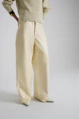 Pantalón de cuero color crema, de corte recto y tiro medio.