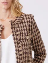 Chaqueta de tweed marca Nanette, color marrón y beige con estampado pata de gallo. Cuello redondo, abertura central, bolsillos delanteros y puños con botones perlados. Terminación desflecada y forro interno.
