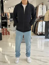 Campera azul marino de felpa con cierre frontal completo, cuello mao, bolsillos tipo canguro y logo bordado en el pecho.