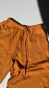 Pantalón de mujer color naranja, de corte palazzo y cintura alta con cordón ajustable.