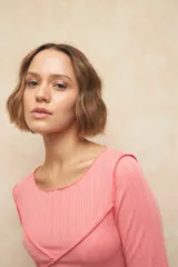 Remera negra de manga tres cuartos, escote redondo y detalle de costuras superpuestas de forma asimétrica.