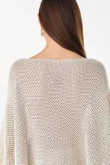 Blusa de punto estilo poncho en color beige, con diseño amplio, cuello redondo y aplique de etiqueta con el logo de la marca en el borde inferior.