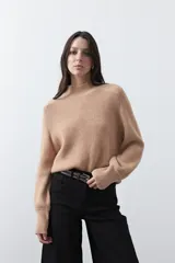 Polera de tejido de punto en color marrón oscuro, con cuello alto y diseño de silueta relajada.