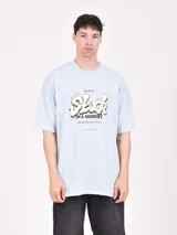 Remera de corte oversize color celeste, con estampa frontal con diseño tipográfico estilo graffiti y texto descriptivo.